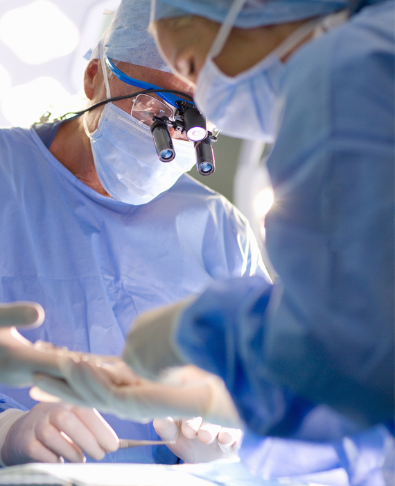 Image of male and female surgeons in the OR looking down